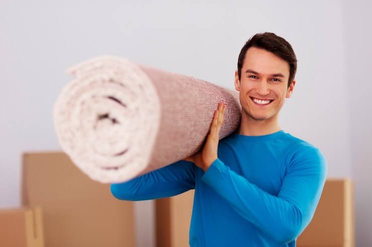 Happy Male Carrying Carpet for New Home